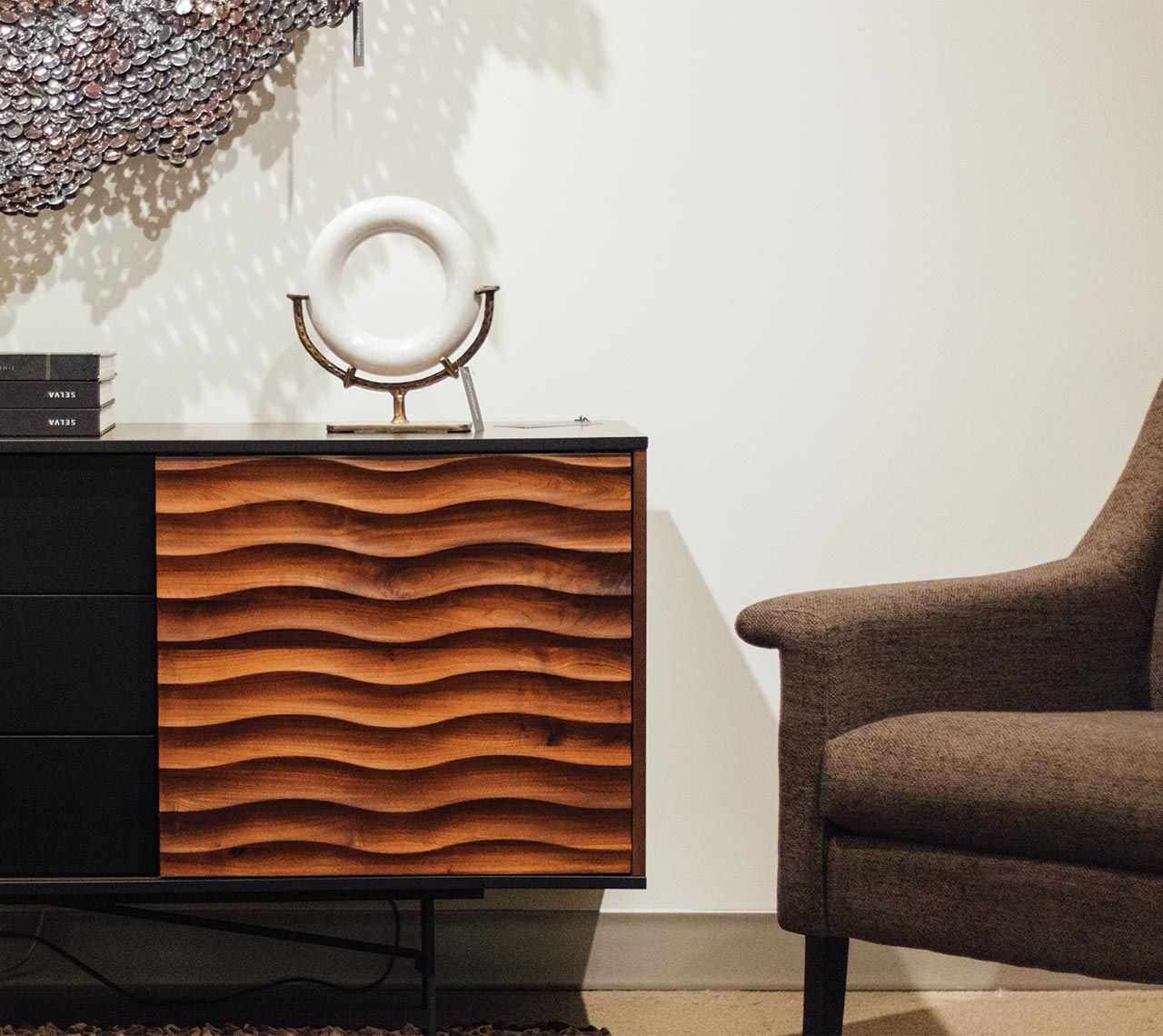 Living room decor collection including brown fabric chair, coffee table, and design pieces. Available at Cottswood Interiors Edmonton